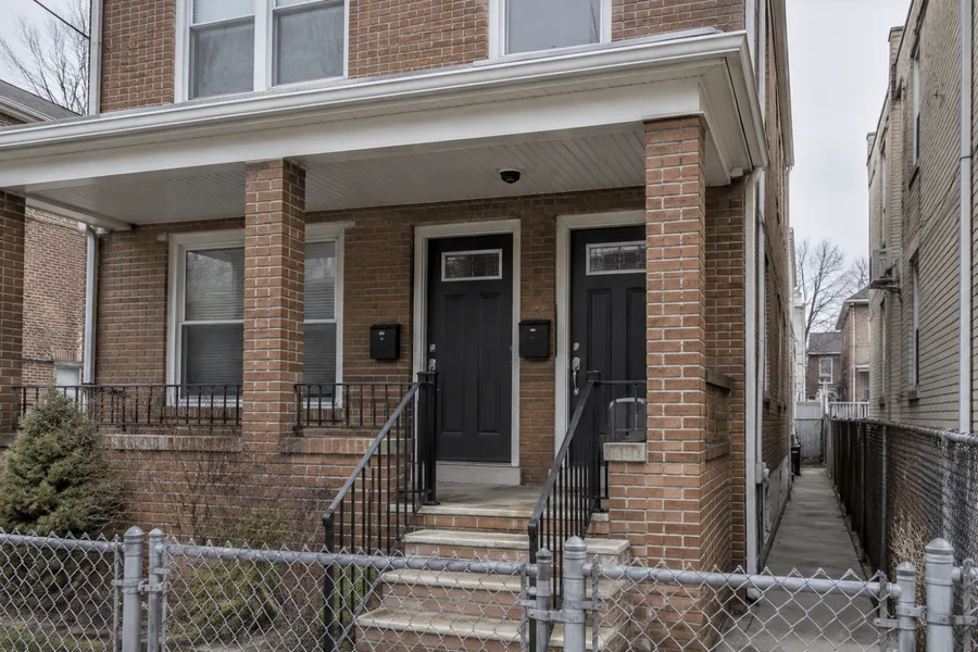Camera over the shared entrance of a brick two-family house